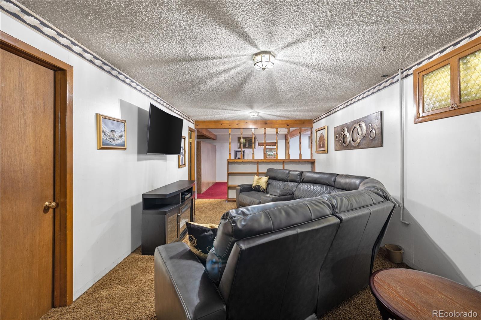 5311 Troy Street Denver, CO 80239 - Photo 30 of 46 a living room with furniture and a flat screen tv