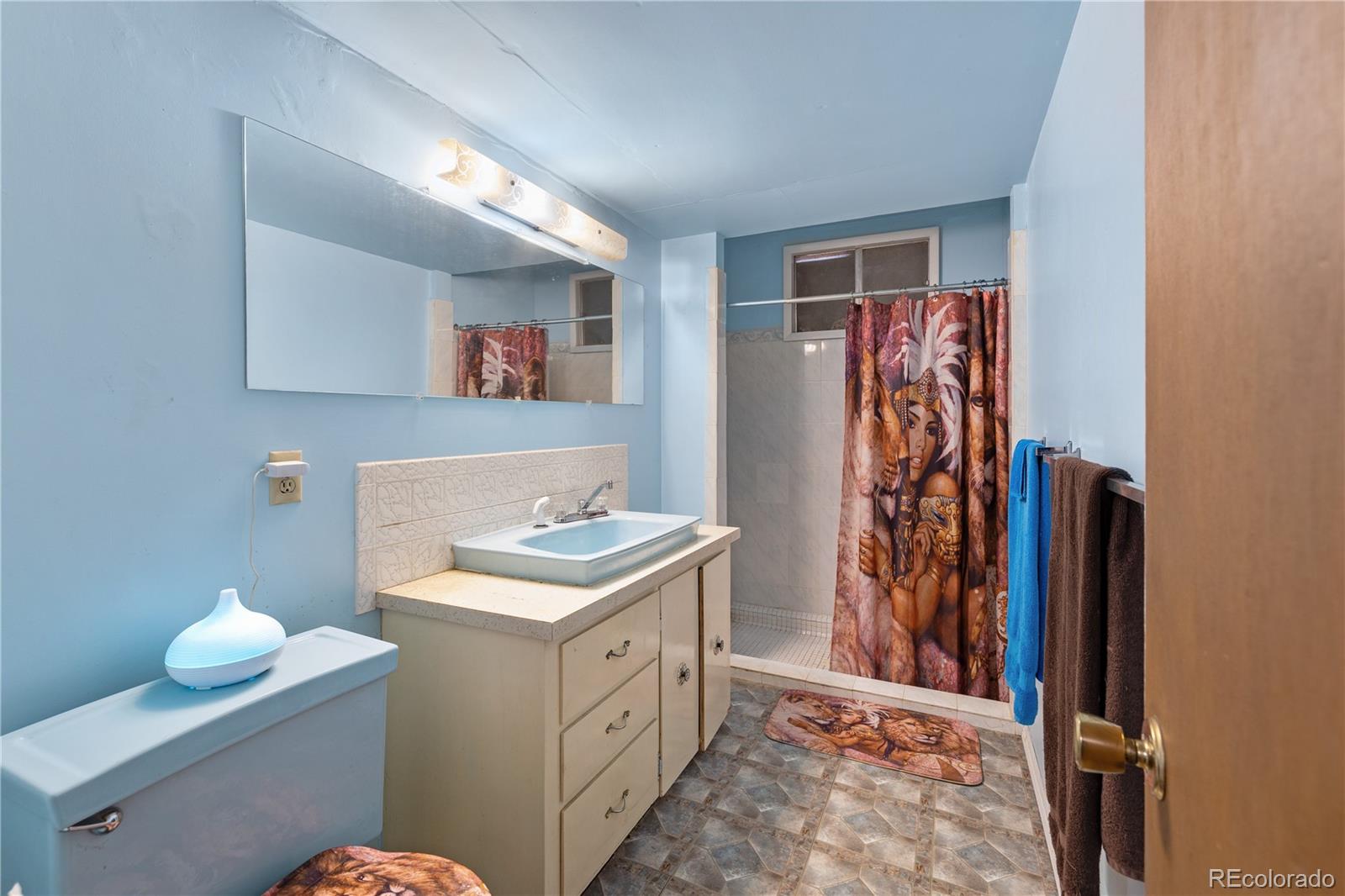 5311 Troy Street Denver, CO 80239 - Photo 32 of 46 a bathroom with a sink toilet and shower