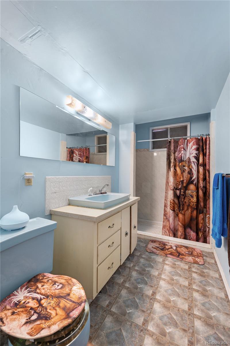 5311 Troy Street Denver, CO 80239 - Photo 33 of 46 a bathroom with a toilet sink and mirror