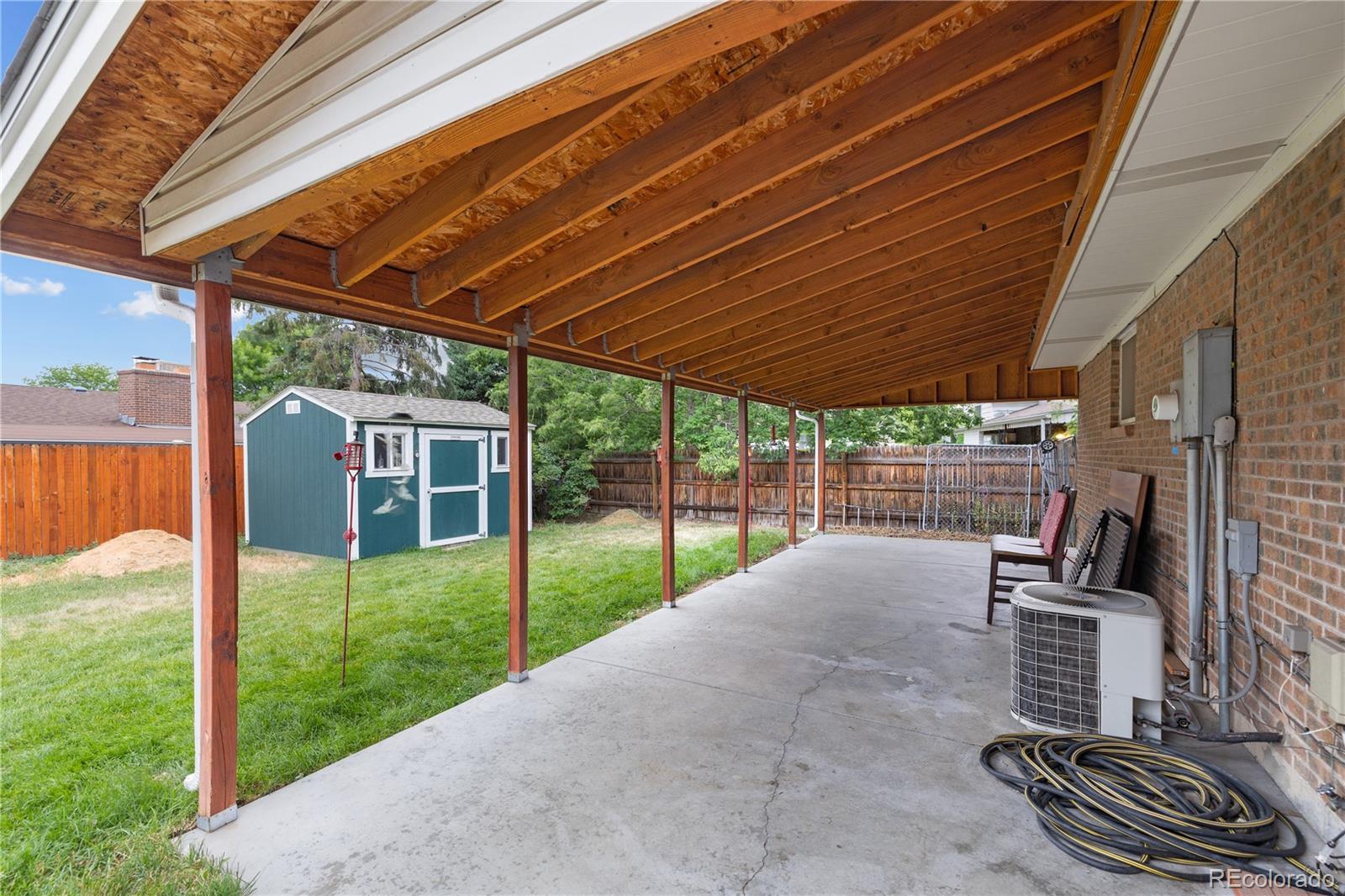 5311 Troy Street Denver, CO 80239 - Photo 44 of 46 a view of a backyard with couches under an umbrella