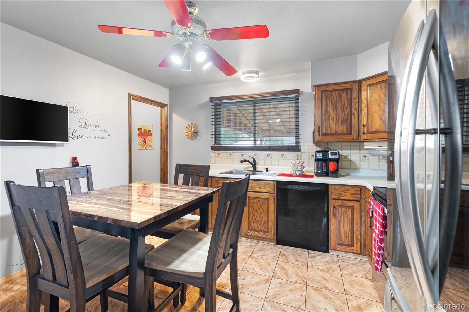 5311 Troy Street Denver, CO 80239 - Photo 9 of 46 a kitchen with a table chairs refrigerator and microwave