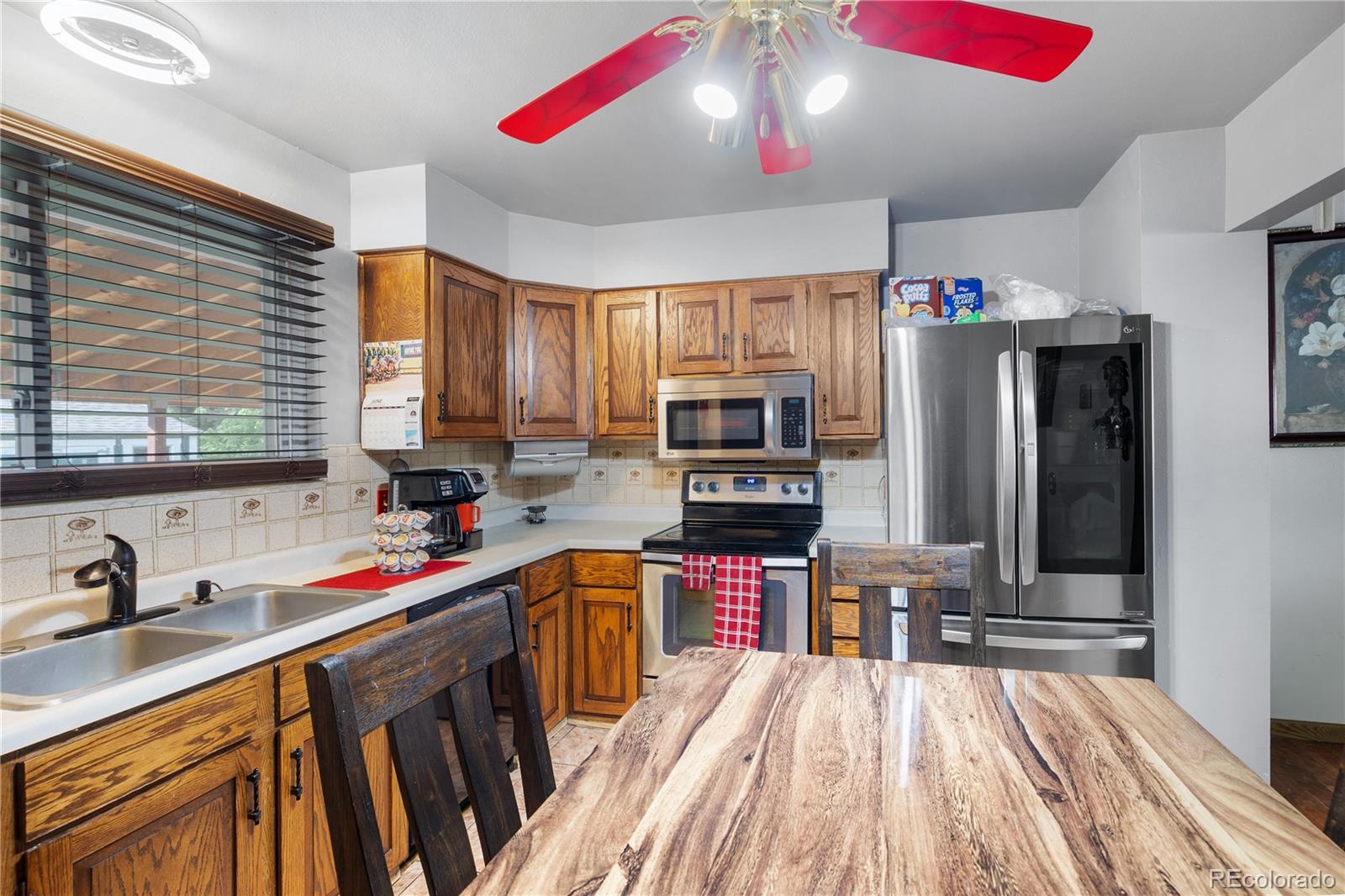 5311 Troy Street Denver, CO 80239 - Photo 10 of 46 a kitchen that has a lot of cabinets a sink dishwasher and a stove with wooden floor