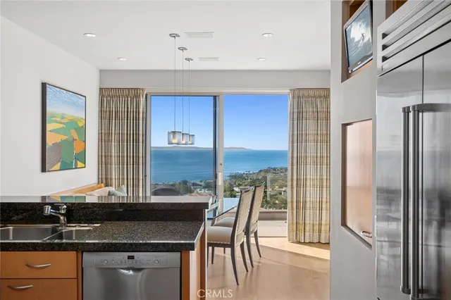a kitchen with stainless steel appliances granite countertop a sink and a refrigerator