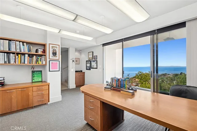a view of kitchen with kitchen island a large window cabinets a sink and stainless steel appliances