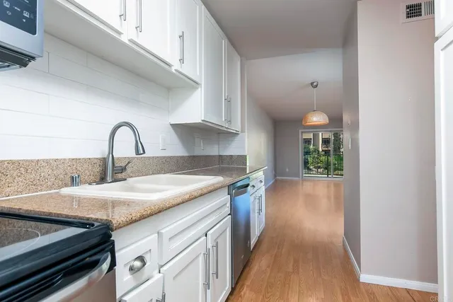 a kitchen with a sink cabinets and wooden floor