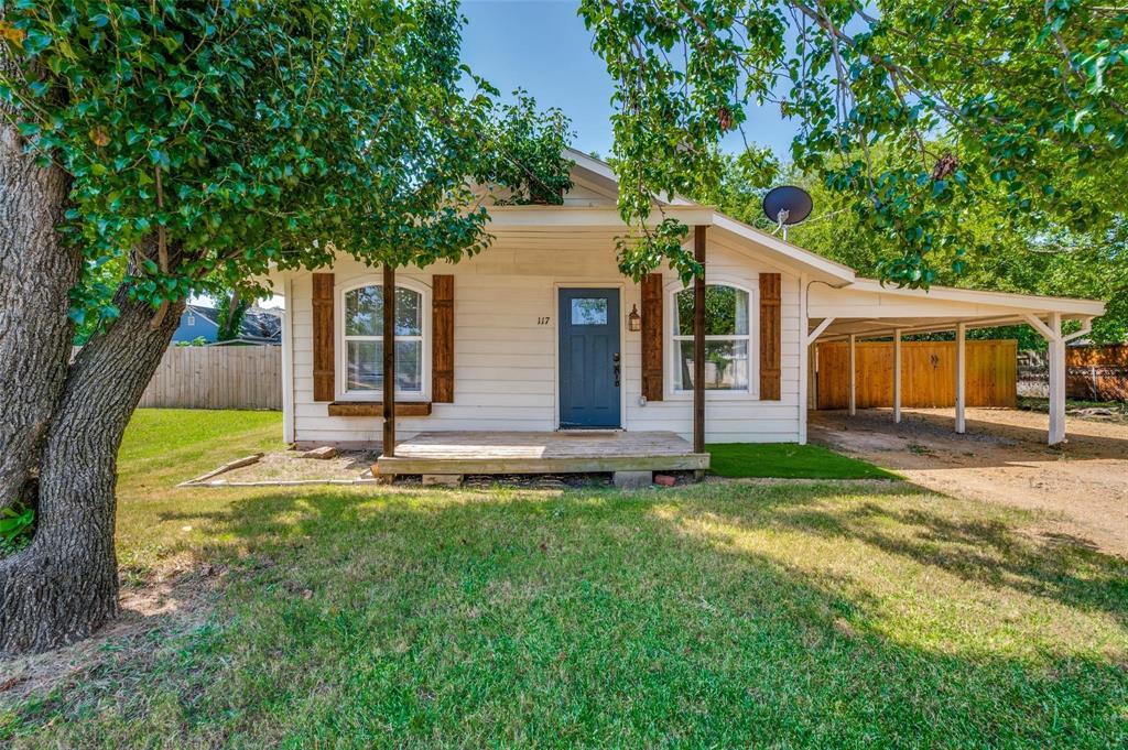 117 East Division Street Pilot Point, TX 76258 - Photo 1 of 19 Single-story residence featuring light-colored siding, a covered front porch, and a dark-toned front door