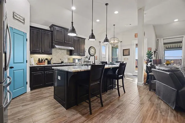 a kitchen with granite countertop a sink cabinets and stainless steel appliances