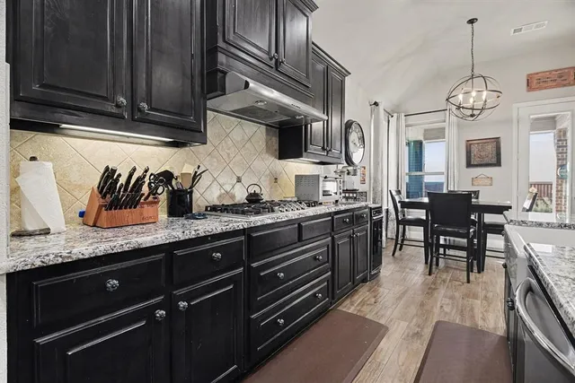 a kitchen with granite countertop stainless steel appliances and wooden cabinets