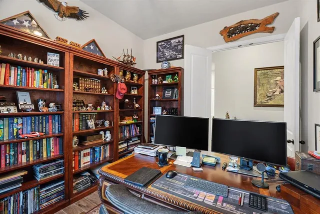 a desktop computer sitting on top of a desk with a book shelf and book shelf