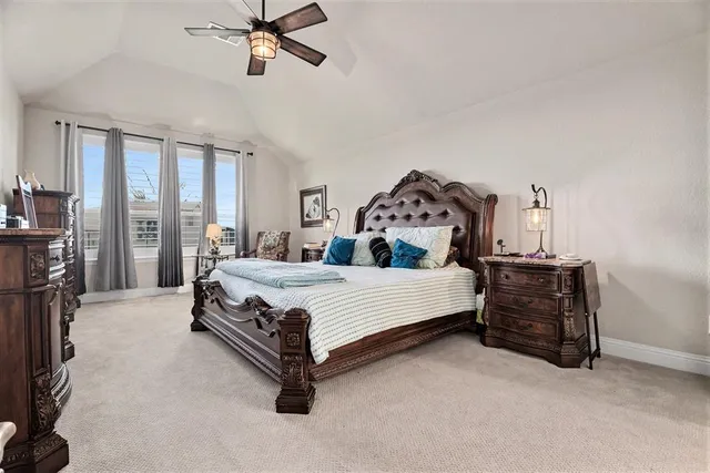 a bed sitting in a spacious bedroom next to a window