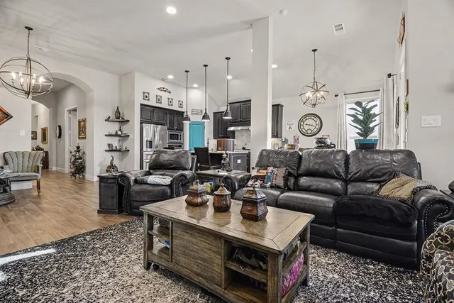 a living room with furniture a clock and a chandelier