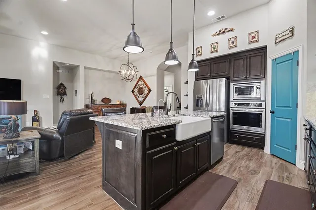 a kitchen with stainless steel appliances granite countertop a stove and cabinets