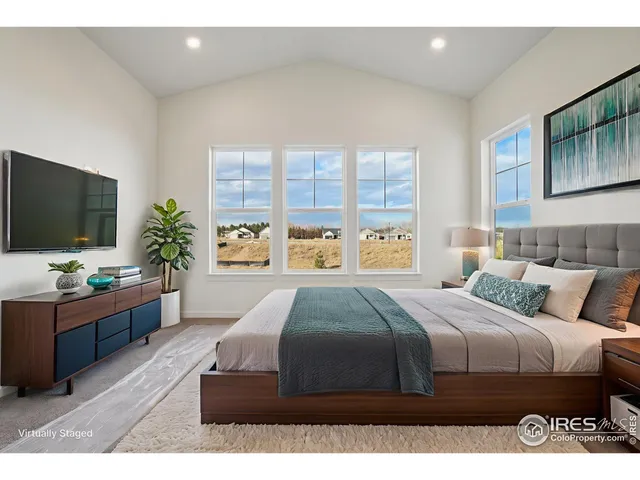 a bedroom with a large bed and a flat screen tv