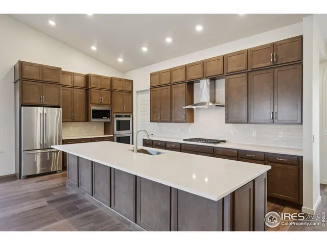a kitchen with a sink a refrigerator and wooden cabinets