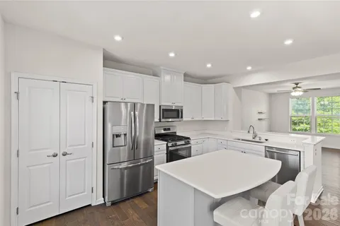a kitchen with a sink a center island a counter space and a window