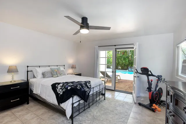 a bedroom with a bed a chandelier and a window