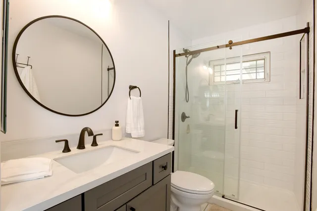 a bathroom with a sink a toilet and a mirror