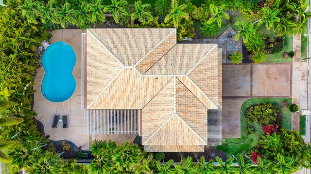 an aerial view of a house with swimming pool and garden