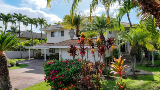 a view of a house with a yard and potted plants