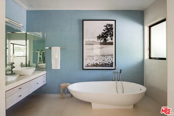 a bedroom with bed and a painting on the wall