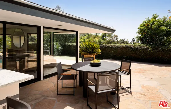 a view of a patio with a table and chairs under an umbrella