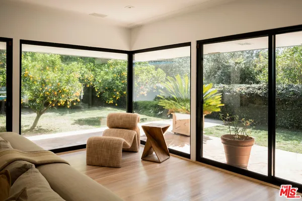 a living room with furniture and a floor to ceiling window