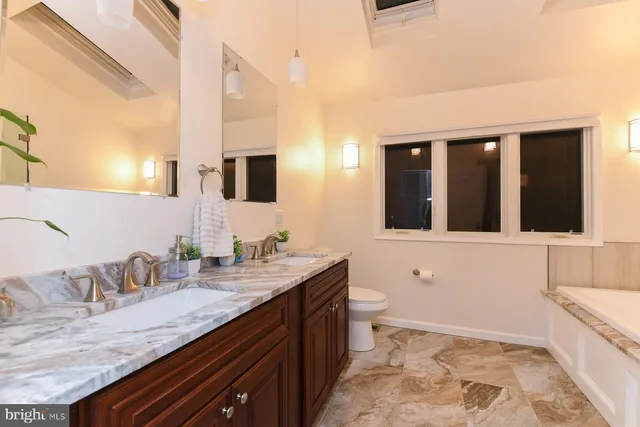 a bathroom with a granite countertop sink and a large mirror