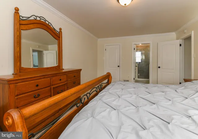 a bedroom with a bed and a mirror on dresser