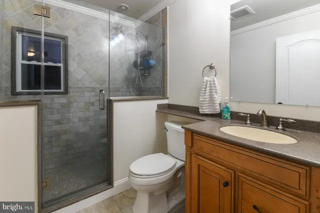 a bathroom with a granite countertop sink toilet and shower