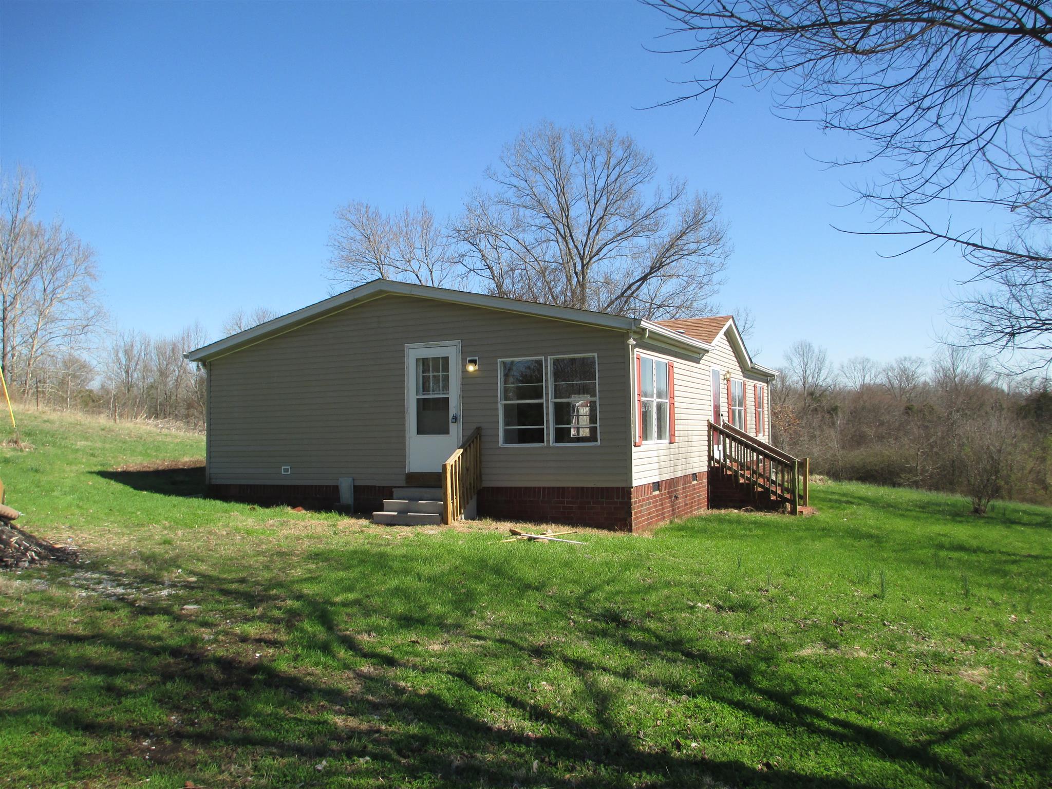 2849 Beasleys Bend Road Lebanon, TN 37087 - Photo 2 of 18 a house that is sitting in the grass with large trees and plants