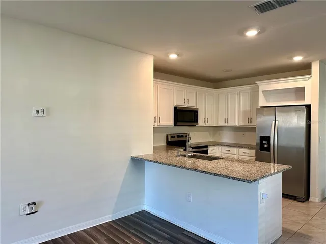 a kitchen with a refrigerator and a stove top oven