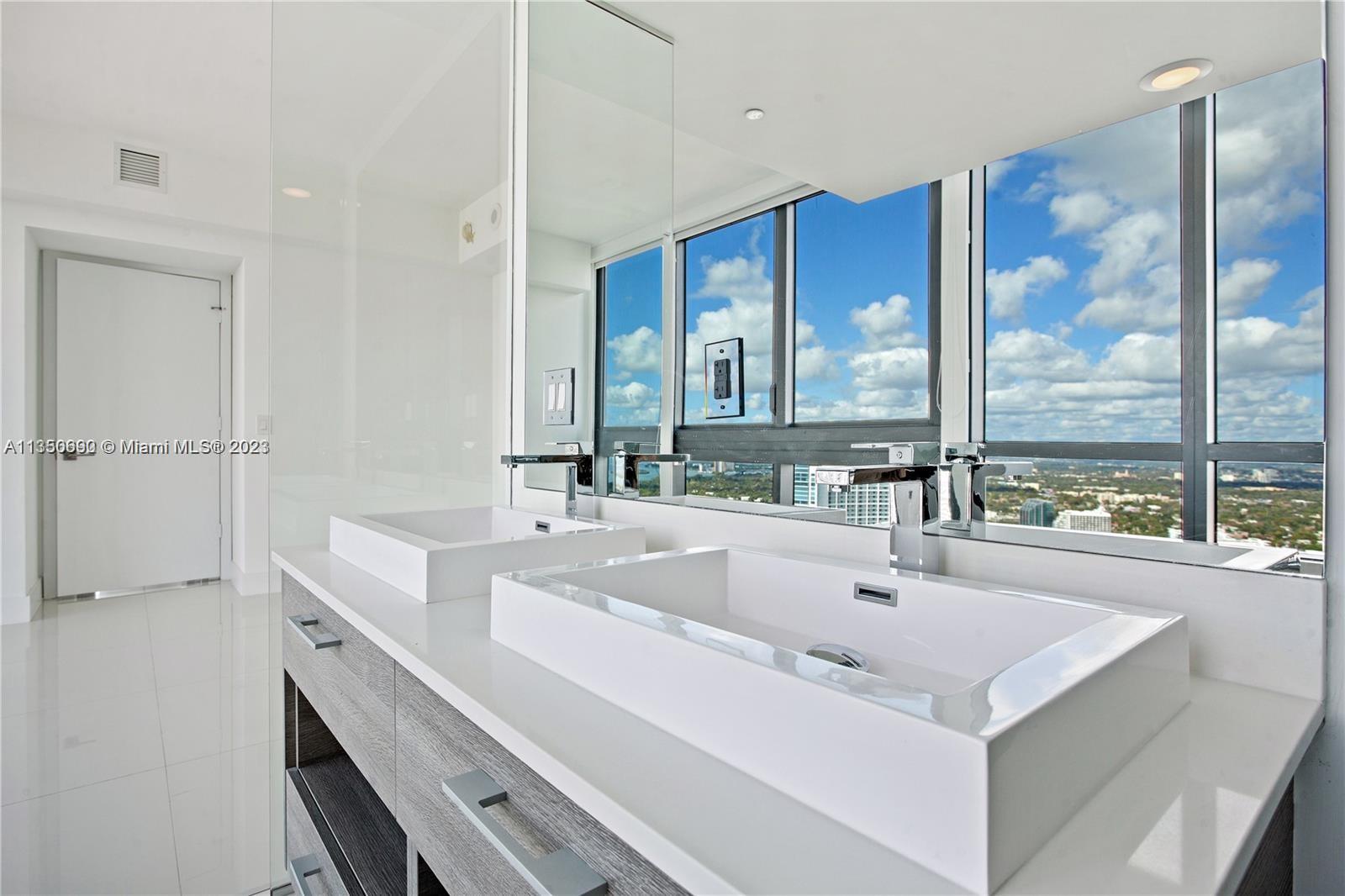 650 Northeast 32nd Street, Unit 4208 Miami, FL 33137 - Photo 6 of 18 a spacious bathroom with a double vanity sink and a large mirror