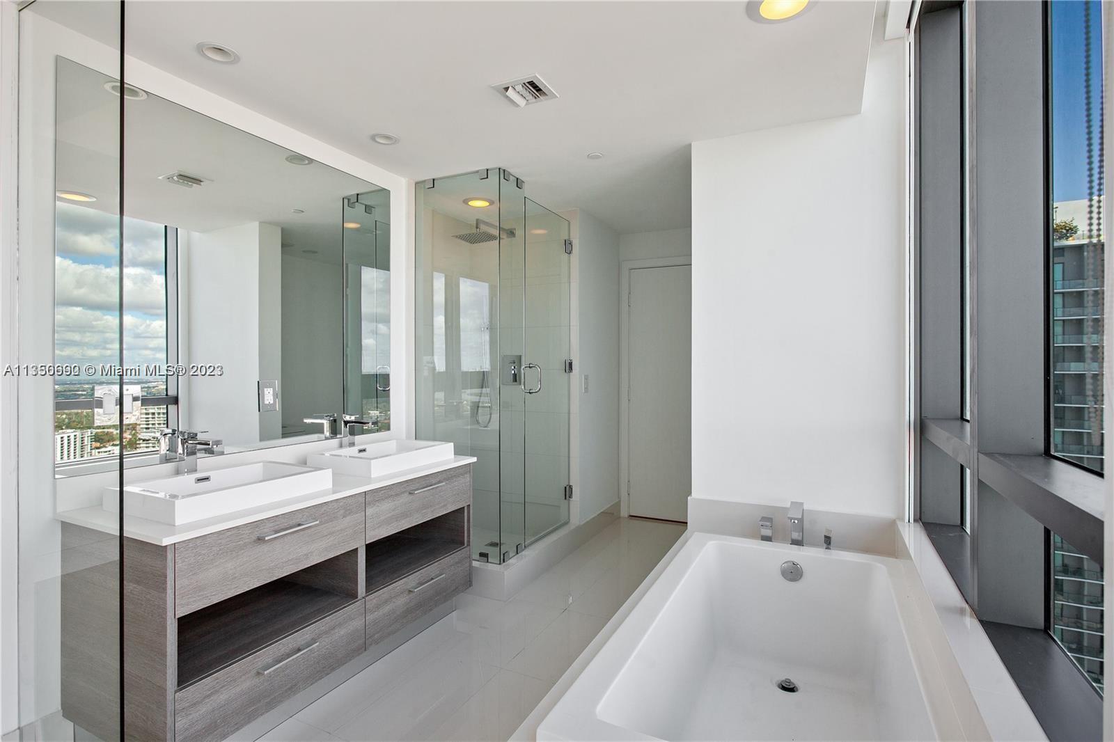 650 Northeast 32nd Street, Unit 4208 Miami, FL 33137 - Photo 8 of 18 a spacious bathroom with a tub double sink and mirror
