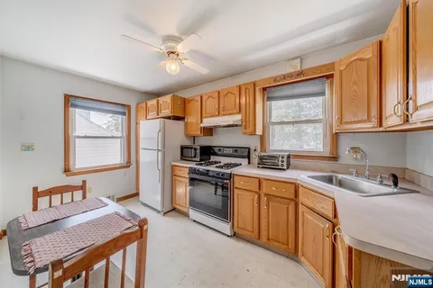 a kitchen with a sink stove top oven and refrigerator