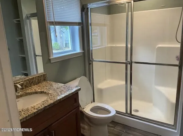 a bathroom with a granite countertop sink toilet and shower