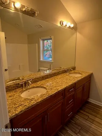 a bathroom with a granite countertop sink and a mirror