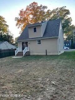 a view of a house with a yard and large tree