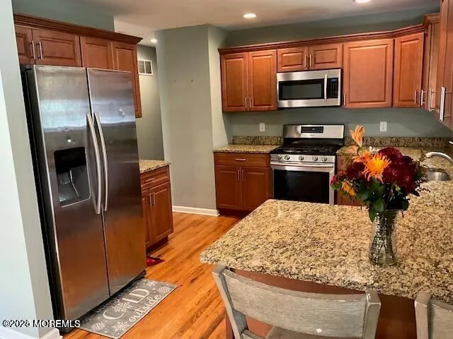 a kitchen with stainless steel appliances granite countertop a refrigerator a stove top oven a sink and dishwasher