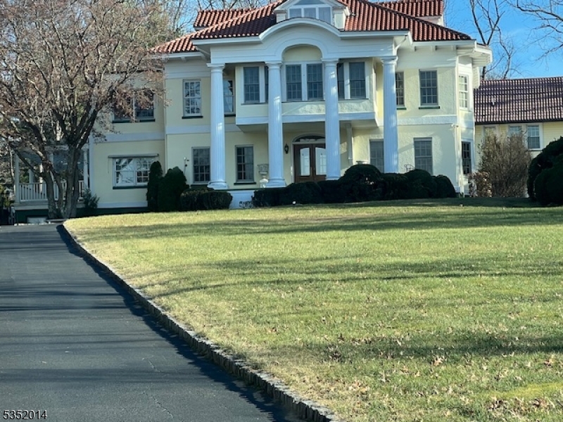 130 Runnymede Road West Caldwell, NJ 07006 - Photo 1 of 13 a view of a brick house with many windows