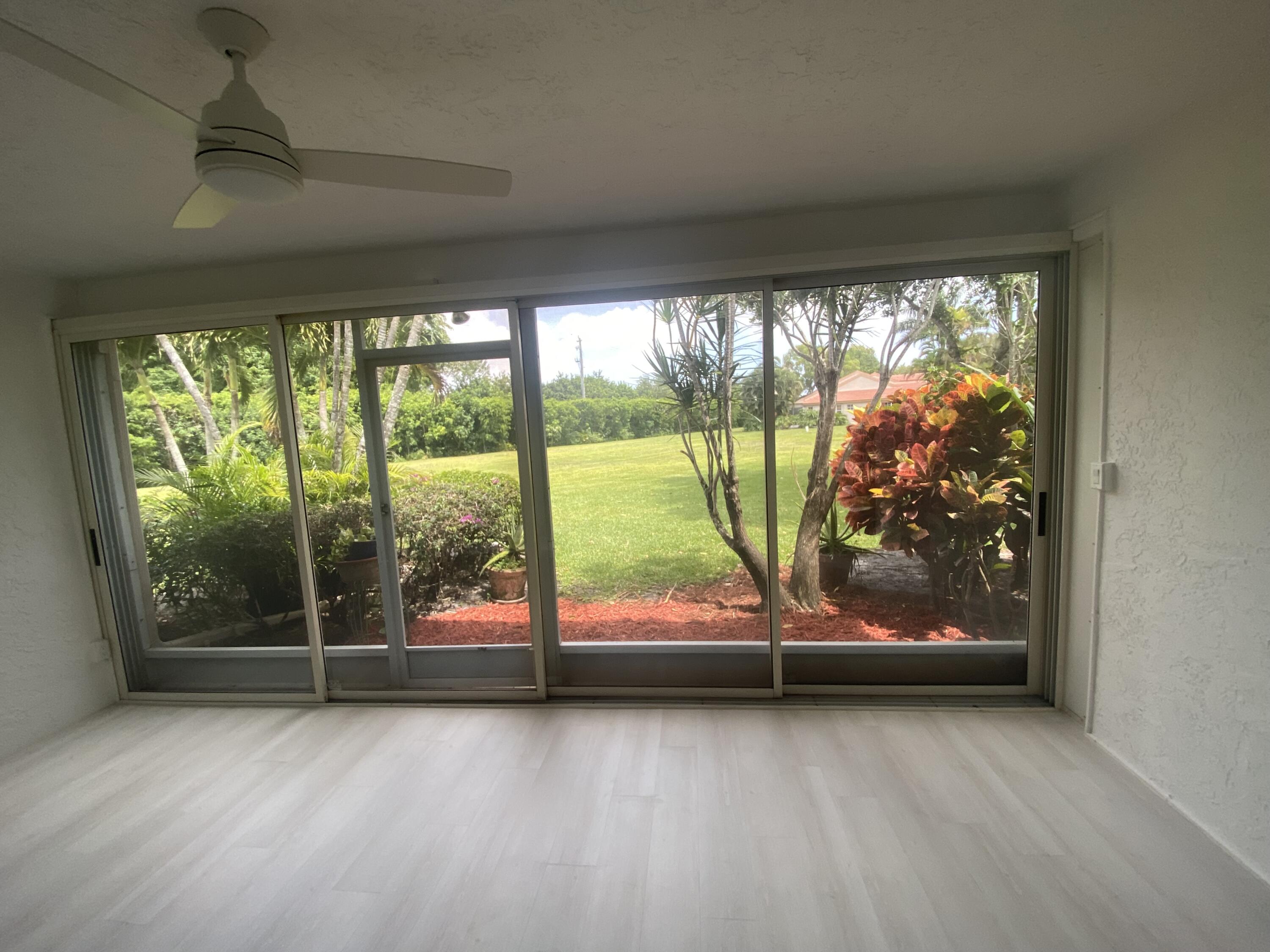 7591 Red Ruby Drive Delray Beach, FL 33446 - Photo 14 of 29 an empty room with wooden floor and floor to ceiling window
