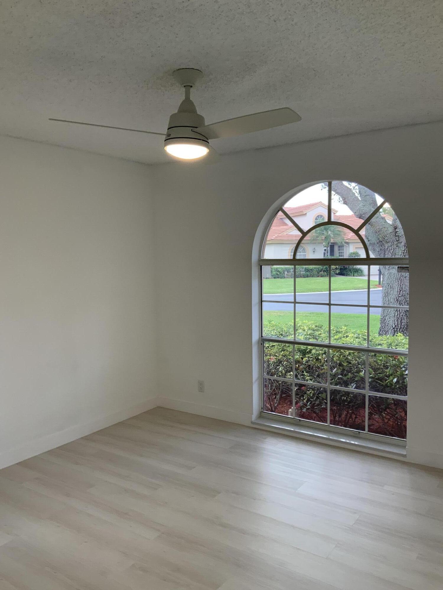 7591 Red Ruby Drive Delray Beach, FL 33446 - Photo 16 of 29 an empty room with wooden floor and outdoor view