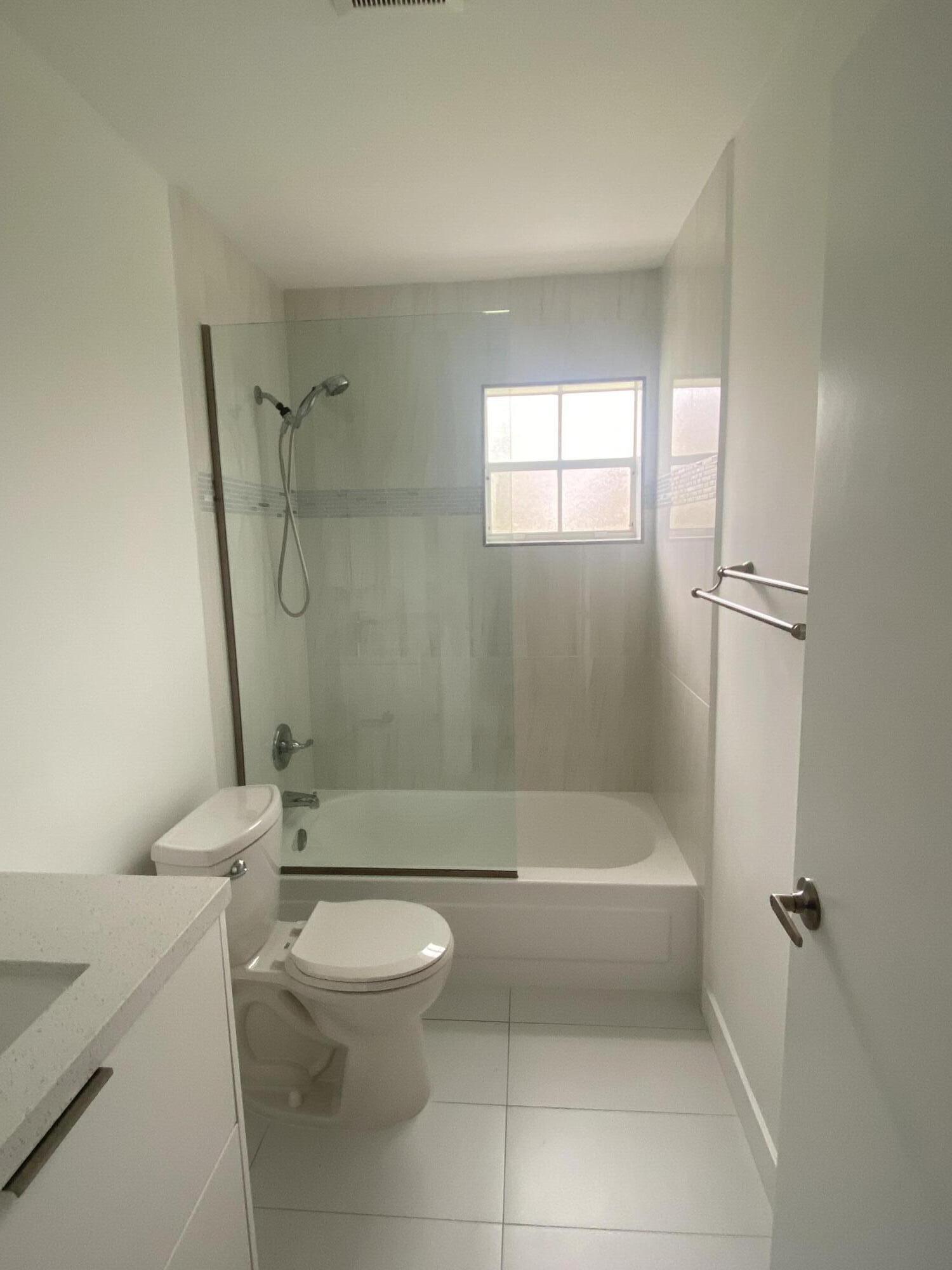 7591 Red Ruby Drive Delray Beach, FL 33446 - Photo 20 of 29 a bathroom with a toilet and a shower