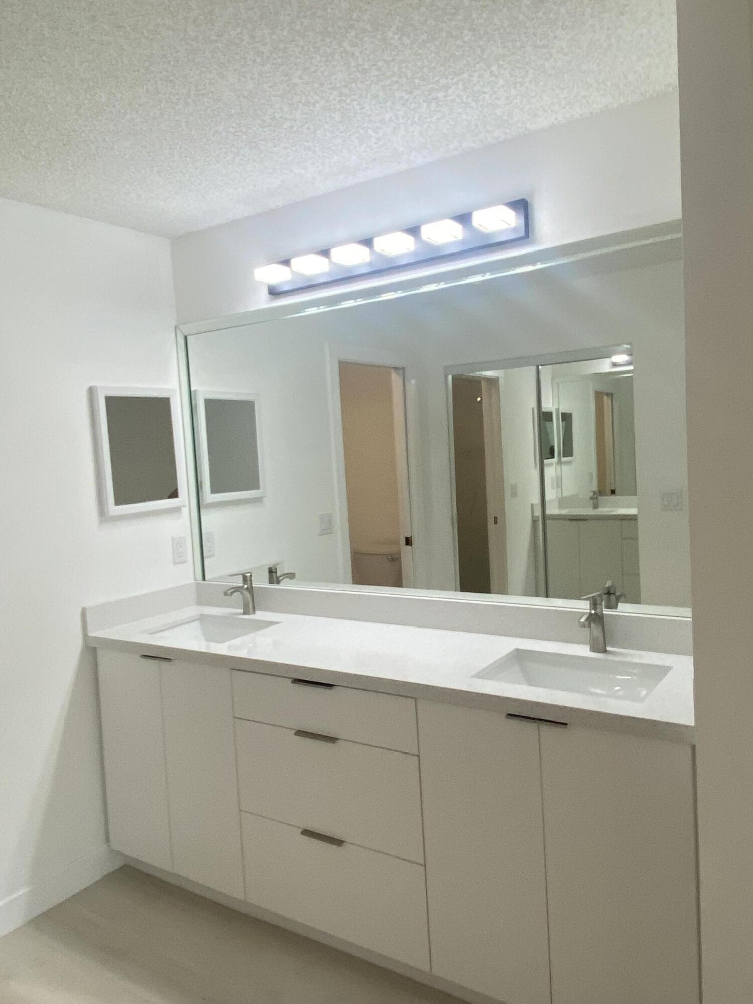 7591 Red Ruby Drive Delray Beach, FL 33446 - Photo 26 of 29 a bathroom with a double vanity sink and a mirror