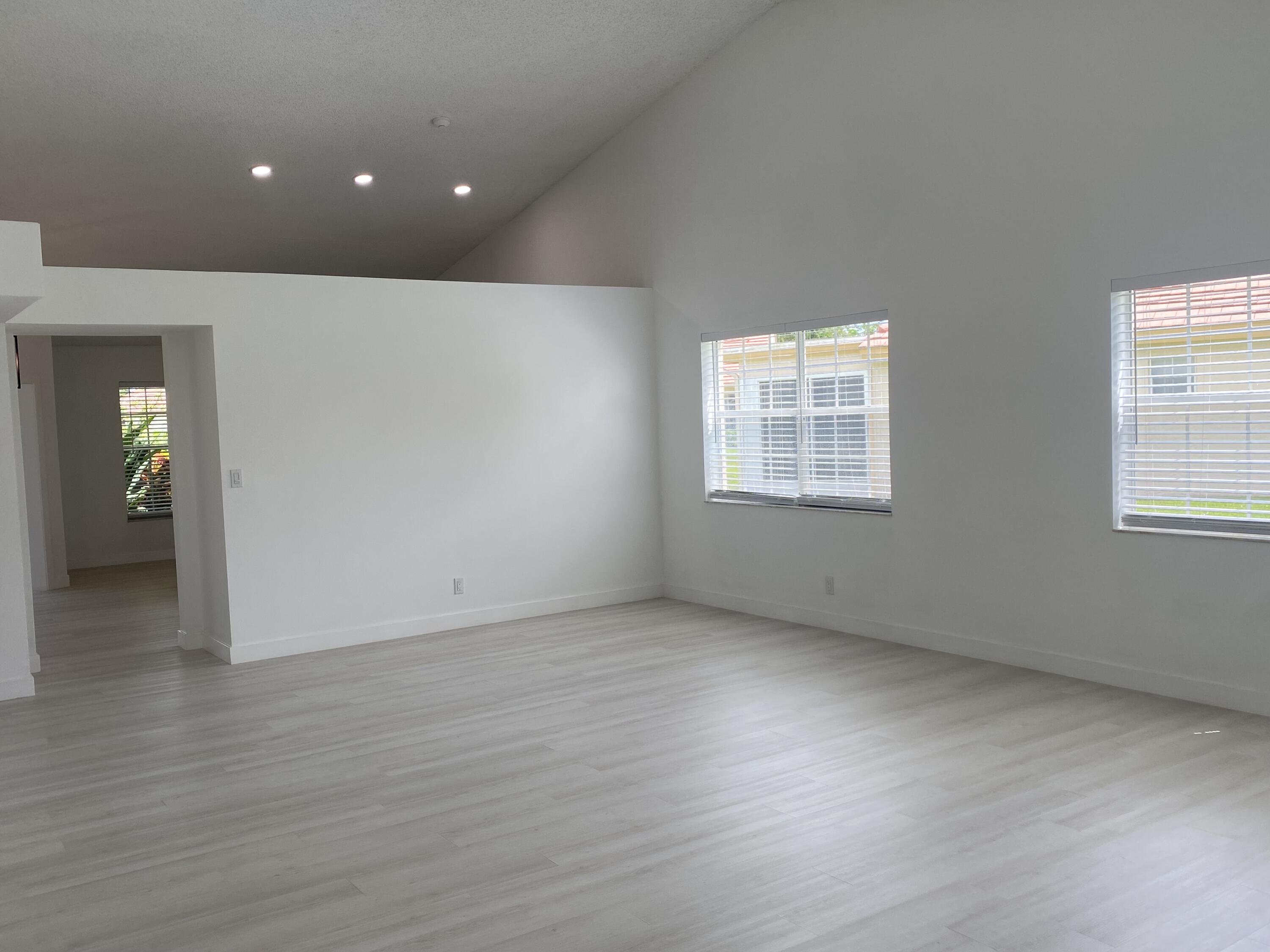 7591 Red Ruby Drive Delray Beach, FL 33446 - Photo 6 of 29 an empty room with wooden floor and windows