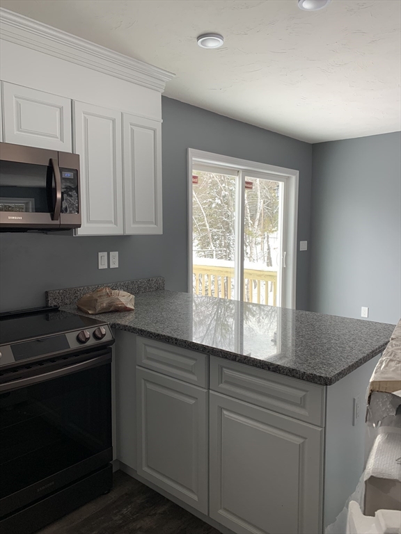 244 Holtshire Road, Unit LOT 4 Orange, MA 01364 - Photo 5 of 17 a kitchen with granite countertop white cabinets appliances a sink and a window