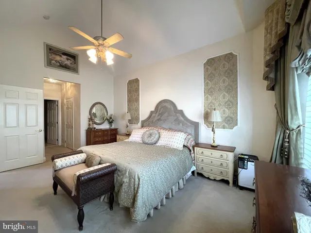 a bedroom with a bed couch and a flat tv screen