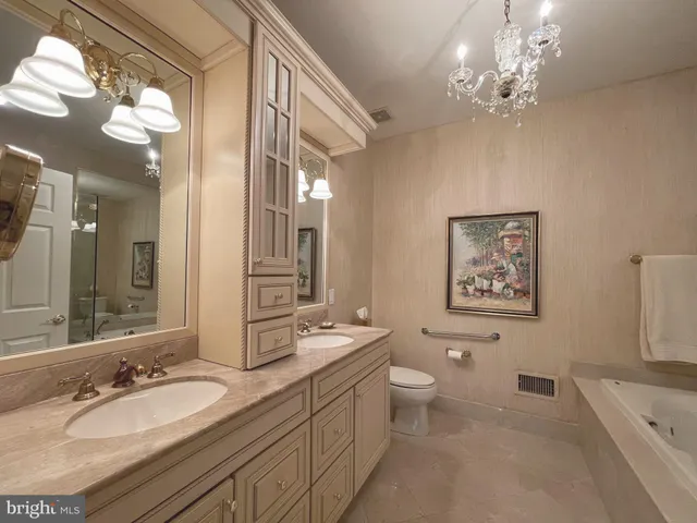 a spacious bathroom with a granite countertop sink a toilet a mirror a vanity and a shower
