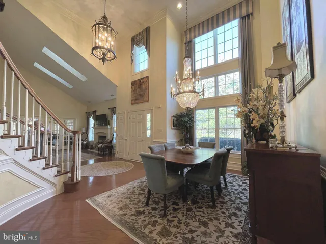 a dining room with wooden floor a chandelier a wooden table and chairs