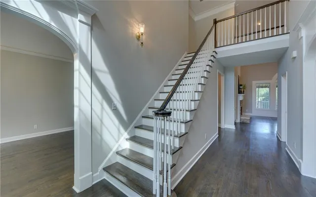 a view of staircase with wooden floor and white walls