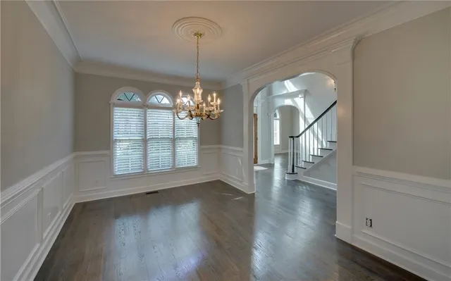 a view of a room with wooden floor chandelier and entryway